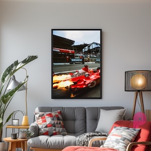 May include: Framed print of a red Formula 1 race car with flames, the Marlboro logo, and the Siemens logo. The car is on a racetrack with a crowd in the background. The print is displayed in a living room setting.
