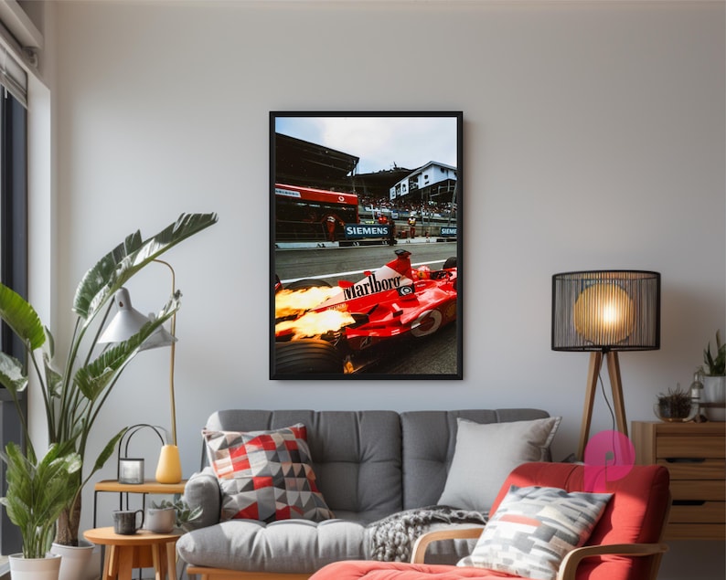 May include: Framed print of a red Formula 1 race car with flames, the Marlboro logo, and the Siemens logo. The car is on a racetrack with a crowd in the background. The print is displayed in a living room setting.