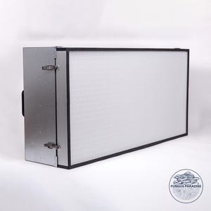 Puede incluir: Una caja de metal plateado con un marco negro y un filtro blanco en su interior. La caja tiene dos cierres en el lateral y un asa en la parte superior. El filtro está hecho de un material de malla fina. La caja está etiquetada con "FUNGUS PARADISE".