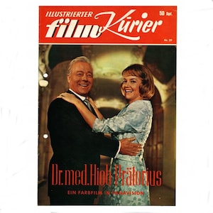 Può includere: Copertina di rivista vintage con un uomo e una donna sorridenti che si abbracciano. Il titolo "Illustrierter Film-Kurier" è in bianco su uno striscione rosso. Il titolo del film "Dr. med. Hiob Prätorius" è in rosso, con "Ein Farbfilm in Panavision" sotto.
