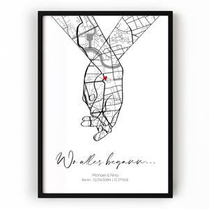 Könnte beinhalten: Schwarz gerahmter Druck mit einer Kartenillustration von zwei Händen, die sich halten, mit einem roten Herz, das einen Ort markiert. Der Text "Wo alles begann..." ist in Schreibschrift geschrieben, zusammen mit Namen und Koordinaten.