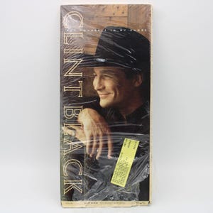 May include: A sealed VHS tape featuring Clint Black. The cover shows a smiling man in a black hat. The title "Clint Black" is vertically printed on the left side. The tape is wrapped in clear plastic.