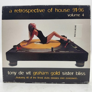 May include: A square music album cover titled A Retrospective of House 91-96 Volume 4. The cover features a black turntable with a gold platter. A person in a black bodysuit is reclining on the platter. Text includes Tony De Vit, Graham Gold, Sister Bliss.