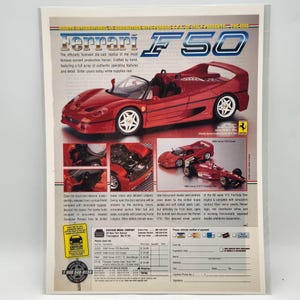 May include: A red Ferrari F50 die-cast model car with white wheels, displayed on a white background. The image includes text about the model's features and details. The model is a replica of the famous Ferrari.