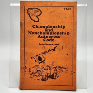 May include: An orange booklet titled "Championship and Nonchampionship Autocross Code" with a cartoon illustration of a car racing towards a finish line. The booklet was revised January 1, 1978.