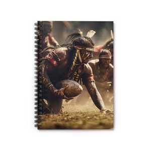 Puede incluir: Cuaderno de espiral con una imagen digitalmente mejorada de jugadores de rugby nativos americanos. La imagen muestra a un jugador con vestimenta tradicional, sosteniendo el balón, con otros jugadores en el fondo. El cuaderno tiene una cubierta blanca.