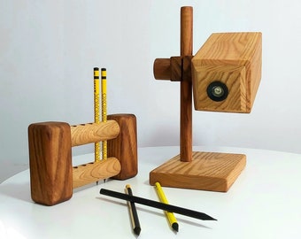 Könnte beinhalten: Holz-Schreibtisch-Organizer mit einem Stiftehalter und einer kleinen Holzlampe. Der Stiftehalter hat drei Fächer für Stifte und die Lampe hat eine kleine Glühbirne. Der Organizer ist aus Naturholz gefertigt und hat einen rustikalen Look.