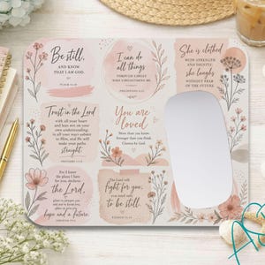 May include: A rectangular mouse pad featuring a soft pink and white floral design with various inspirational religious quotes and scripture verses, including Be still, I can do all things, She is clothed with strength, and Trust in the Lord.