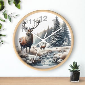 May include: A round wall clock with a light wood frame. The clock face features a winter landscape with a deer, a stream, and snow-covered trees. Silver numerals and hands complete the design.
