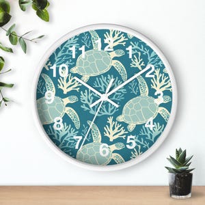 May include: White round wall clock with a blue background and a pattern of sea turtles and coral. The clock face has black hands and white numbers.