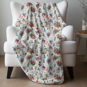 May include: A white throw blanket with a red, white, and blue floral pattern featuring American flags, stars, and top hats.