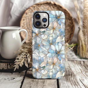 May include: A phone case with a blue and white floral design. The case has a cutout for the camera lens.