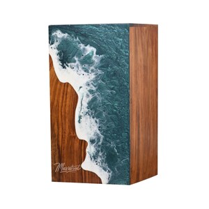 May include: A wooden box with a teal and white resin wave design. The box is made by Maxwood.