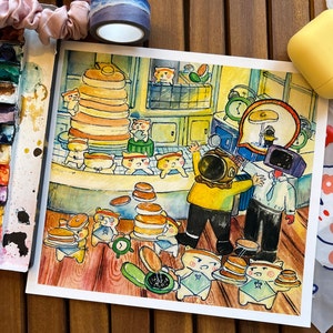 Pode incluir: Ilustração em aquarela de uma cena de restaurante de panquecas. Personagens de desenhos animados, incluindo figuras semelhantes a ursos, são retratados preparando e servindo panquecas. A obra de arte apresenta uma paleta de cores quentes com tons de amarelo, laranja e marrom.