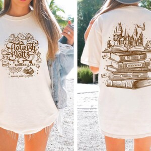 May include: Two white t-shirts with different designs. The front shirt has a brown graphic of the text "Flourish and Blotts Booksellers Diagon Alley, London". The back shirt has a brown graphic of a stack of books with the text "Potions, Herbology, Magical Theory".