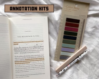 Peut inclure: Un gros plan d'un livre ouvert avec le titre "The Mountain is You" et du texte surligné sur le sabotage de soi. Le livre est sur une surface blanche avec un stylo rose et blanc et un ensemble de notes autocollantes colorées.