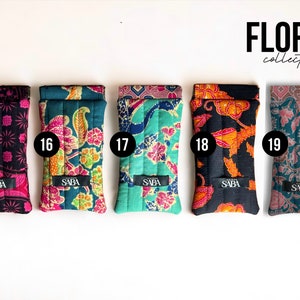 May include: Five quilted phone cases with different floral patterns. The cases are numbered 15 through 19 and have the word "SABA" printed on them. The cases are part of the "FLORES collection".