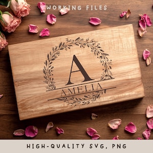 May include: A rectangular wooden chopping board featuring a floral wreath design and the letter "A" in the centre. The name "AMELIA" is engraved below the letter. The words "WORKING FILES" and "HIGH-QUALITY SVG, PNG" are printed on the image.
