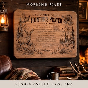 May include: A rectangular wooden sign featuring the engraved text THE HUNTER'S PRAYER, accompanied by illustrations of a deer, a bird, pine trees, and mountains. The design includes decorative flourishes and the word Amen at the bottom.