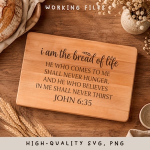 May include: A rectangular wooden cutting board with rounded corners. The text "i am the bread of life" is engraved on the board, along with a Bible verse. The board is surrounded by wheat stalks and other decorative elements.