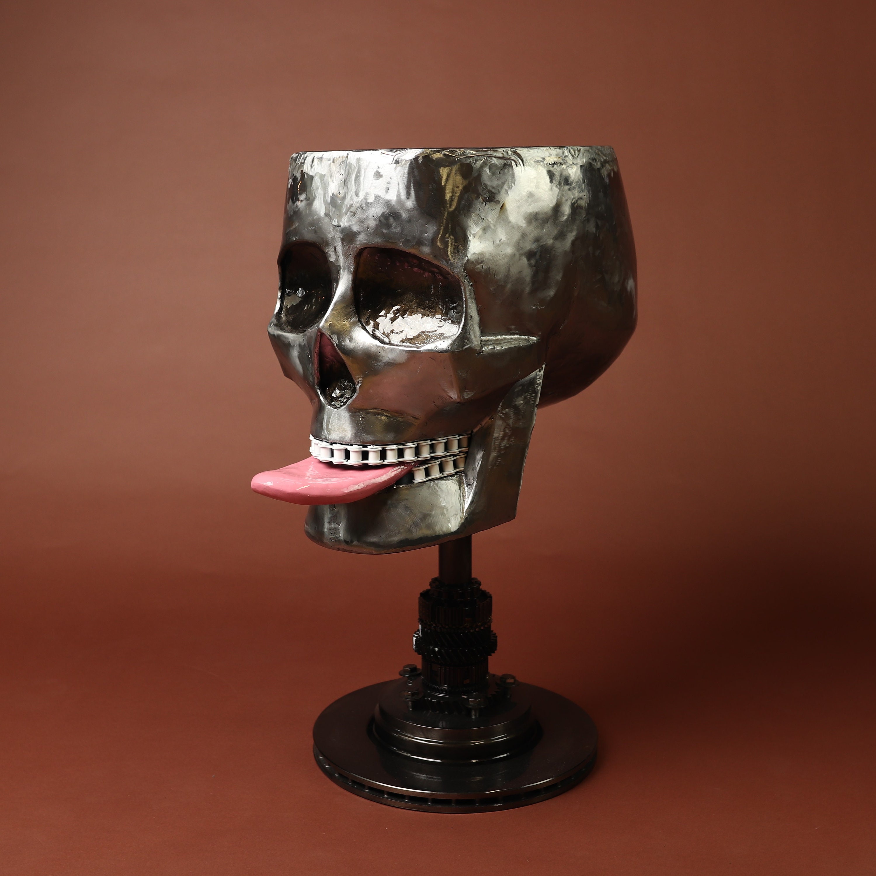 Scrap metal sculpture indoor art: a skull smiley face made out of real engine parts and scrap metal