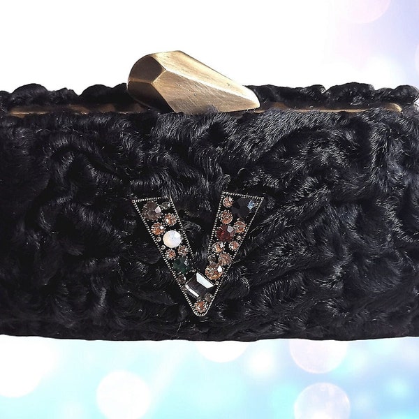 Clutch mini piel de karakul astracán genuino, color negro, boquilla y cierre metálico bronce pulido, frente con V pedrería multicolor