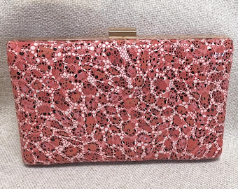 Pochette serie V&R, in vera pelle con stampa esclusiva, con cornice dorata e chiusura a scatto.