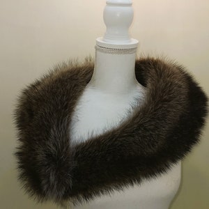 May include: A brown fur collar on a white dress form.