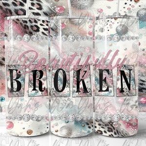 May include: A set of three stainless steel tumblers with a pink, white, and gray abstract design. The tumblers feature a leopard print pattern and the words "Beautifully Broken".