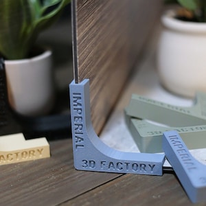 May include: Three corner pieces for woodworking projects. The corner pieces are made of plastic and are blue, beige, and green. The corner pieces have the words "Imperial" and "3D Factory" printed on them.