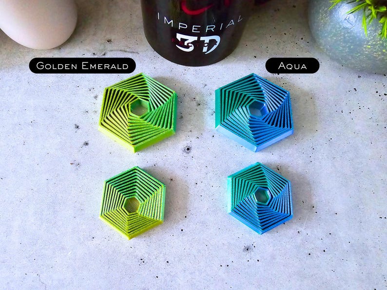 May include: Four hexagonal coasters with a spiral design. Two coasters are green and blue, and the other two are a gradient of green and blue. The coasters are labeled "Golden Emerald" and "Aqua".