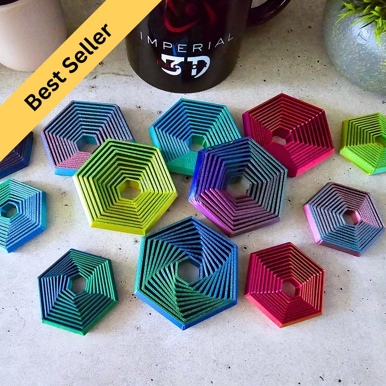 May include: A set of 10 colorful, multi-layered, hexagonal coasters with a gradient effect. Each coaster is made of a different color, including blue, green, red, and purple.