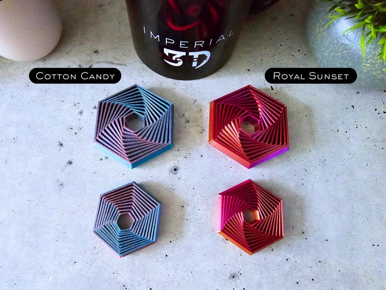 May include: Four hexagonal coasters with a swirling pattern. The coasters are in the colors cotton candy, royal sunset, blue, and red.