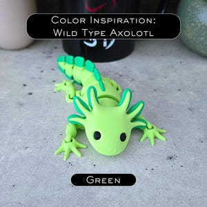 May include: A lime green articulated axolotl figurine with dark green accents on the gills and tail fins. The figure features black circular eyes and a textured surface. Text on the image reads: COLOR INSPIRATION: WILD TYPE AXOLOTL and GREEN.