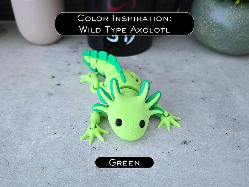May include: A lime green articulated axolotl figurine with dark green accents on the gills and tail fins. The figure features black circular eyes and a textured surface. Text on the image reads: COLOR INSPIRATION: WILD TYPE AXOLOTL and GREEN.