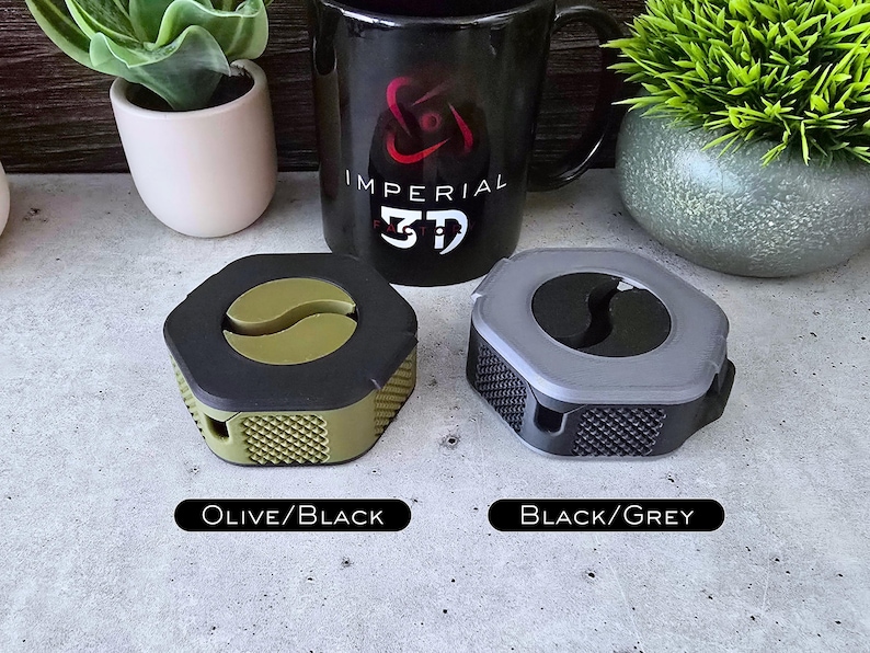 K&ouml;nnte beinhalten: Zwei sechseckige Kabelorganisatoren, einer in Olivgr&uuml;n und Schwarz, der andere in Schwarz und Grau. Beide haben eine schwarze Mitte mit einem Yin-Yang-Symbol. Der Text "Olive/Black" und "Black/Grey" befindet sich unterhalb jedes Organisators.