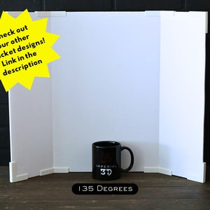May include: A white three-panel backdrop with a 135-degree angle, perfect for product photography. A black mug with the text "IMPERIAL 3D" is in the center of the backdrop.