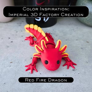 May include: A 3D printed articulated axolotl figure in red with yellow accents on the gills and tail fins. The figure features black eyes and a textured surface. Text on the image reads: COLOR INSPIRATION: IMPERIAL 3D FACTORY CREATION and RED FIRE DRAGON.