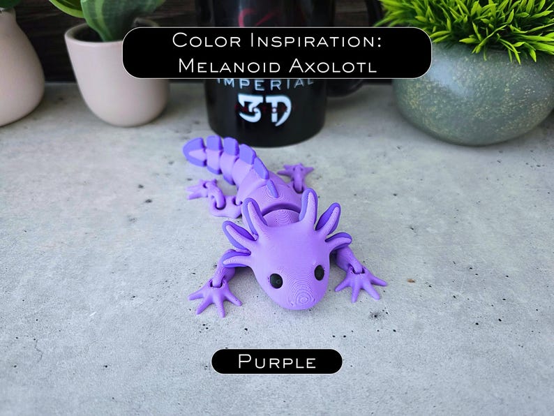 May include: A purple articulated axolotl figurine with black eyes and a segmented tail. The figure features external gills and four limbs. Text above reads Color Inspiration: Melanoid Axolotl, and text below reads Purple.
