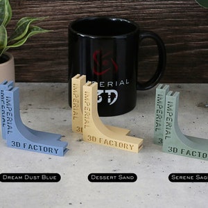 May include: Three 3D printed corner brackets in different colors: Dream Dust Blue, Dessert Sand, and Serene Sage. Each bracket has the text "IMPERIAL 3D FACTORY" printed on it.