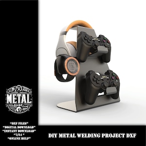 May include: A DIY metal welding project DXF file for a stand to hold two video game controllers and a pair of headphones. The stand is made of metal and has a black finish. The controllers are black and the headphones are white with a brown headband. The stand is on a white background.