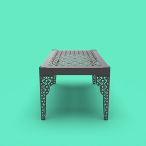 May include: A black metal table with a geometric pattern cut out of the top and legs. The table is on a turquoise background.
