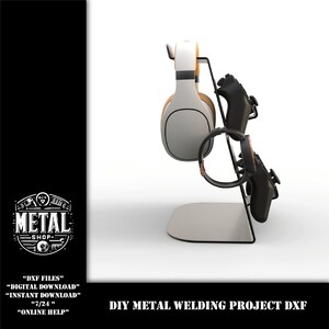 May include: A black metal stand with two slots for holding a pair of headphones and two video game controllers. The stand is on a white surface. DIY METAL WELDING PROJECT DXF