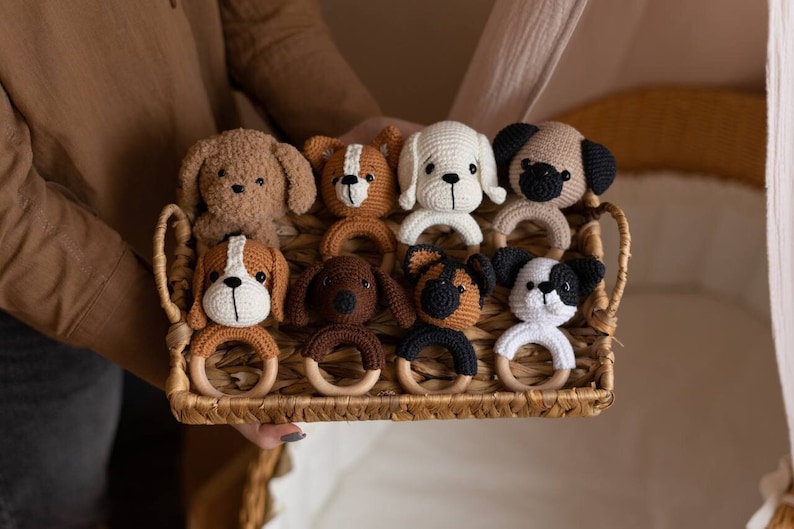 May include: A set of eight crocheted dog rattle toys in a variety of colors and patterns. The toys are arranged in a wicker basket.