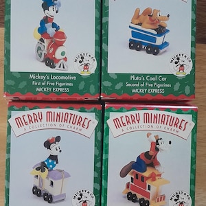 May include: Four boxed "Merry Miniatures" figurines from the Mickey Express collection. The boxes feature Mickey Mouse on a locomotive, Pluto in a coal car, Minnie Mouse in a luggage car, and Goofy in a caboose. Each box has the Mickey & Co. logo.