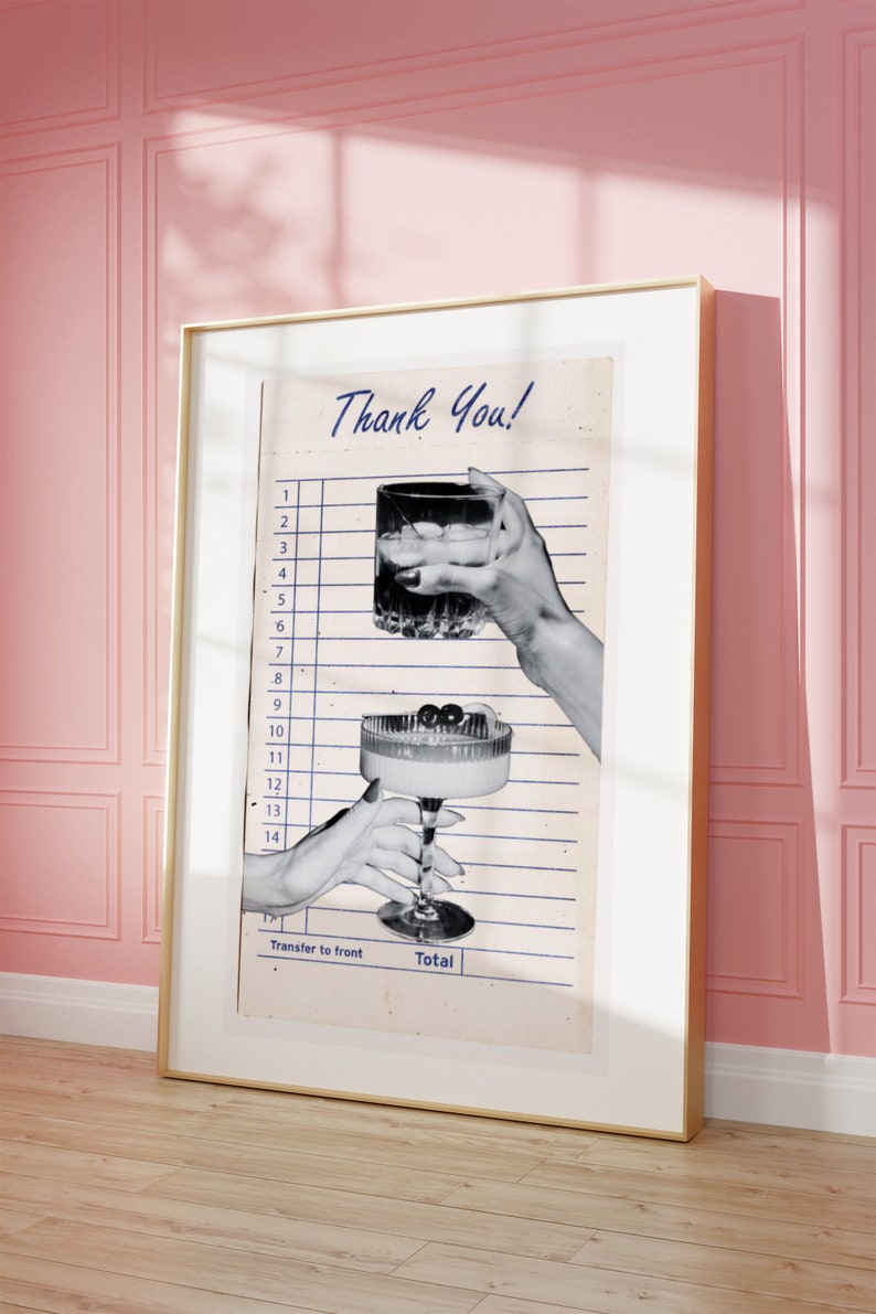 May include: A framed print featuring a vintage-style receipt with the words "Thank You!" in blue script. The image shows two hands holding cocktails, one a rocks glass and the other a coupe glass with cherries. The frame is gold.