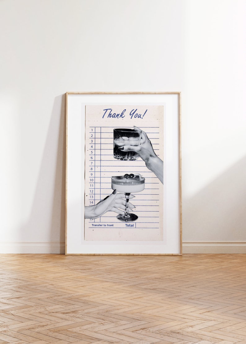 May include: A framed print featuring a vintage-style receipt with the words "Thank You!" in blue script. Two hands are holding cocktails, one a rocks glass and the other a coupe glass. The print is in a gold frame.