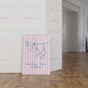 May include: A pink and white striped poster with a blue line drawing of two bikini tops hanging on a clothesline. The text "dolce far niente" is written in blue below the bikini tops.