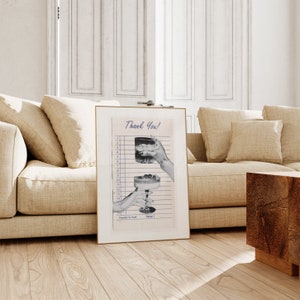 May include: A framed print featuring a vintage-style receipt with the words "Thank You!" at the top. The image shows two hands holding cocktails, one with ice and the other with cherries. The frame is gold.