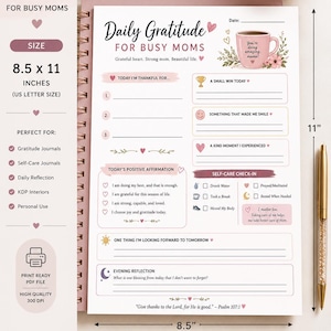 May include: A spiral-bound gratitude journal page measuring 8.5 by 11 inches. The white paper features pink accents, a coffee mug illustration with the text 'You're doing amazing, mama!', sections for daily gratitude, positive affirmations, and self-care.
